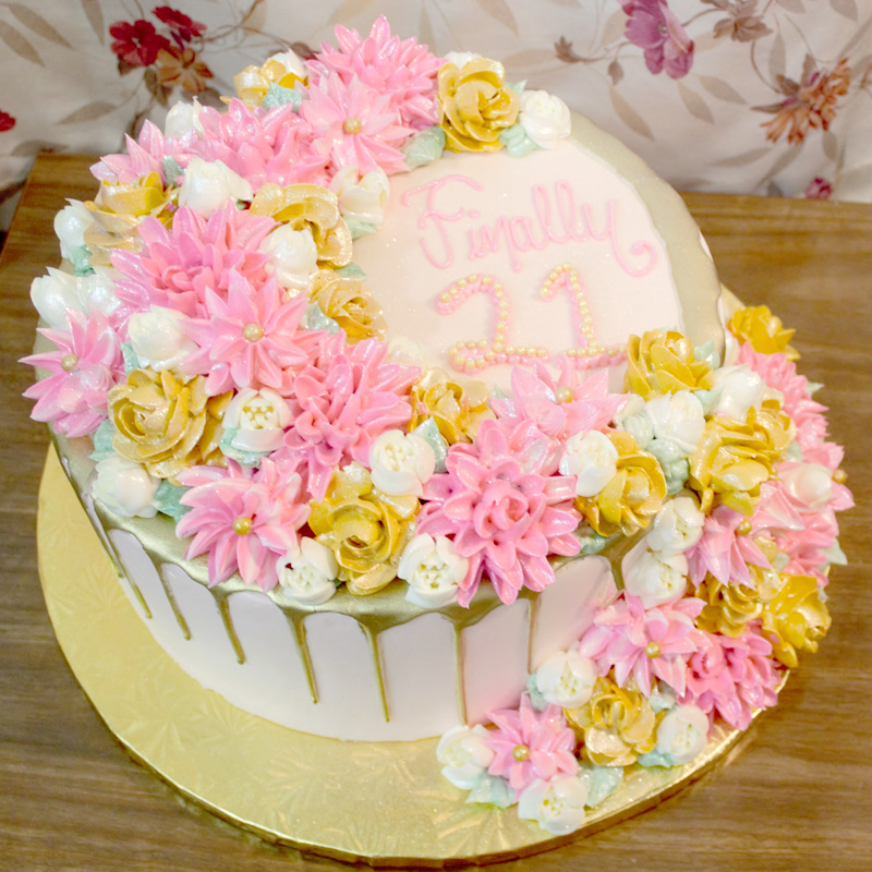 Pink and Gold Blooms Cascading Flowers Over Gold Drip Cake